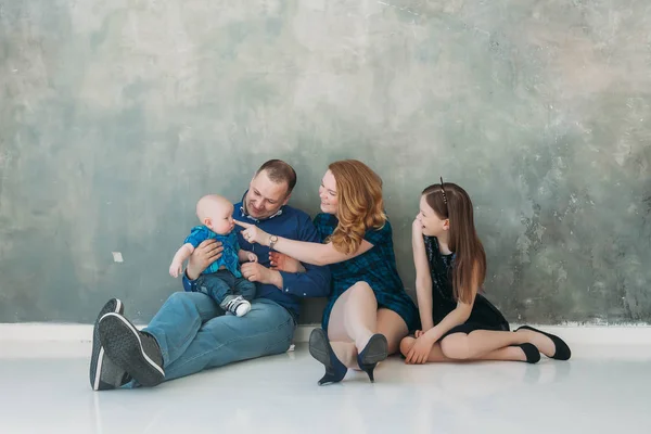 Feliz retrato de família situado no fundo cinza branco sala de chão dia ensolarado — Fotografia de Stock