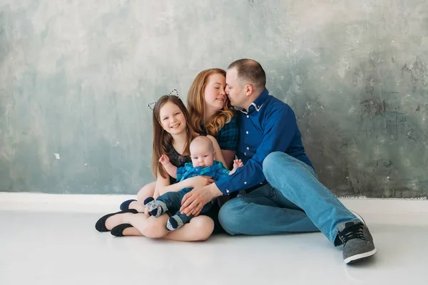 Feliz familia retrato sentado en gris fondo blanco piso habitación día soleado — Foto de Stock