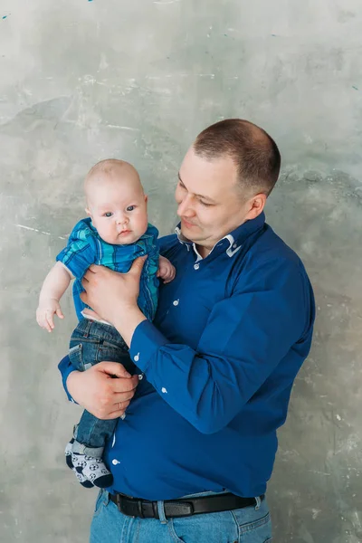 Feliz familia retrato padre e hijo pequeño de pie sobre fondo gris piso blanco habitación día soleado —  Fotos de Stock