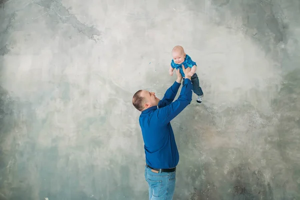 Feliz familia retrato padre e hijo pequeño de pie sobre fondo gris piso blanco habitación día soleado — Foto de Stock