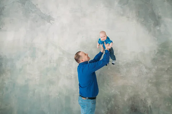 Feliz familia retrato padre e hijo pequeño de pie sobre fondo gris piso blanco habitación día soleado — Foto de Stock
