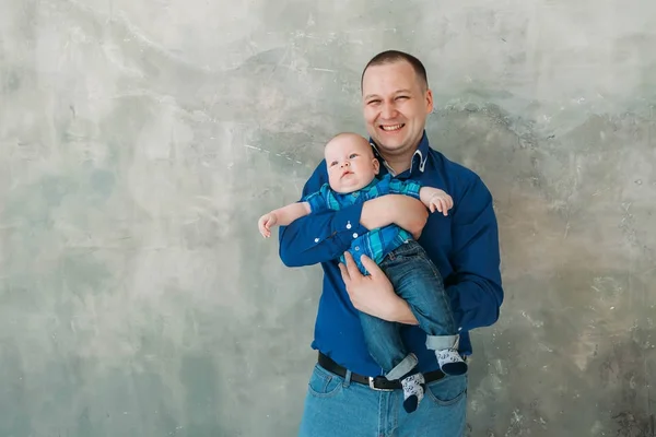 Glücklich Familienporträt Vater und kleiner Sohn stehen auf grauem Hintergrund weißer Boden Zimmer sonnigen Tag — Stockfoto