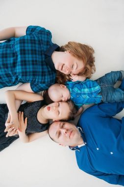 Mutlu aile anne baba kızı oğul portre beyaz zemin Oda stüdyo mavi üzerinde yalan