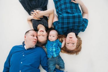 Mutlu aile anne baba kızı oğul portre beyaz zemin Oda stüdyo mavi üzerinde yalan