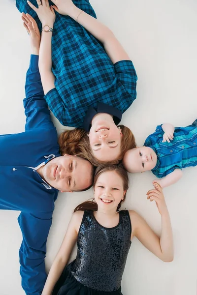 Mutlu aile anne baba kızı oğul portre beyaz zemin Oda stüdyo mavi üzerinde yalan — Stok fotoğraf
