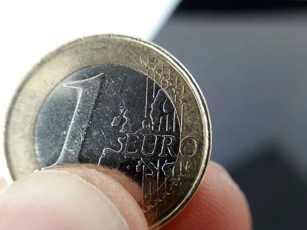 Macro foto de una moneda de euro entre los dedos . —  Fotos de Stock