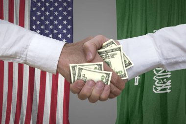 100 dolar faturaları karşılıklı ABD ve Suudi Arabistan bayrağı arka plan ile.