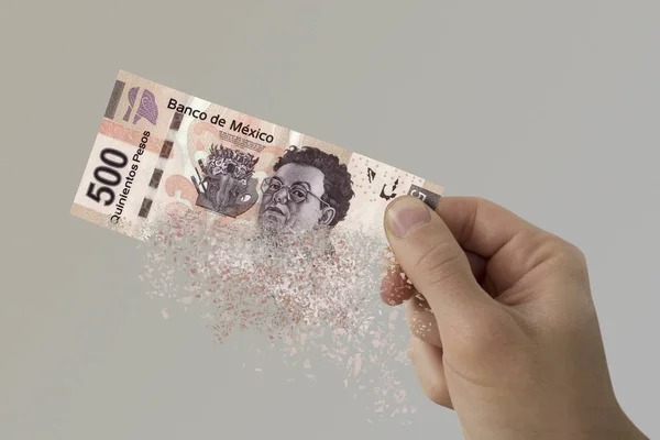 Five hundred Mexican Pesos bill pulverizes in a man's hand. — Stock Photo, Image