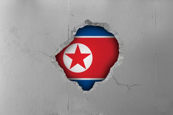 North Korean flag behind a concrete wall.