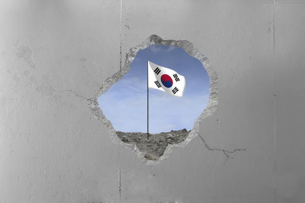 South Korean flag behind a concrete wall.