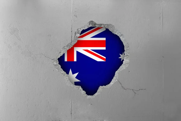 Australian flag behind a concrete wall.
