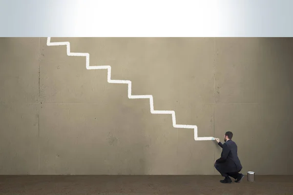 A business man draws stairs on a concrete barrier.