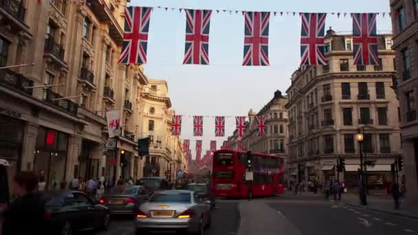 ロンドン イギリス 9月2016 ユニオンジャックの旗で飾られたリージェントストリートの夜のタイムラプス リージェントストリートはロンドンの西端にある主要なショッピングストリートです — ストック動画
