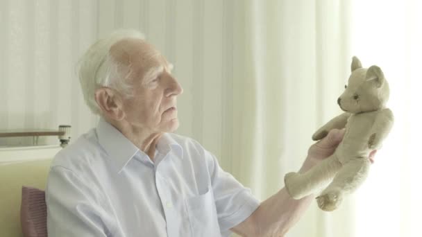 Senior Kaukasiska Mannen Håller Gamla Nalle Teman För Att Påminna — Stockvideo