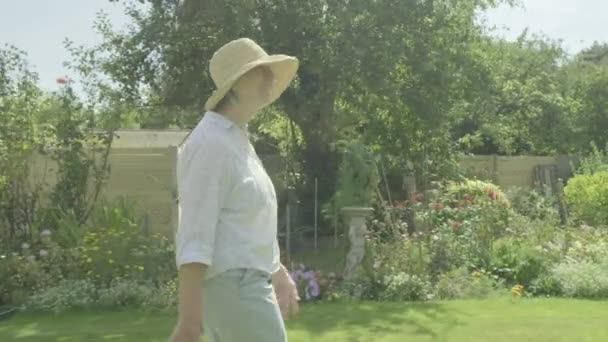 退職園芸活動的なシニアの彼女の庭のテーマを歩くシニア白人女性の着実なカムビュー — ストック動画