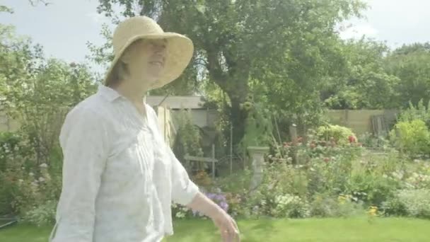 退職園芸活動的なシニアの彼女の庭のテーマを歩くシニア白人女性の着実なカムビュー — ストック動画