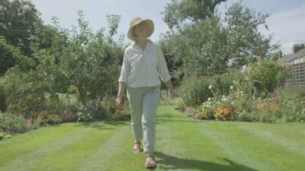 Steady Cam View Senior Caucasian Woman Walking Her Garden Themes — 비디오