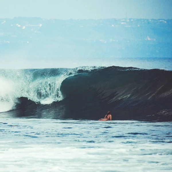 Frau schwimmt auf Surfbrett — Stockfoto