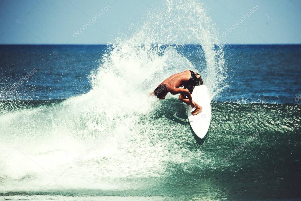 surfer catching breaking wave in Bali