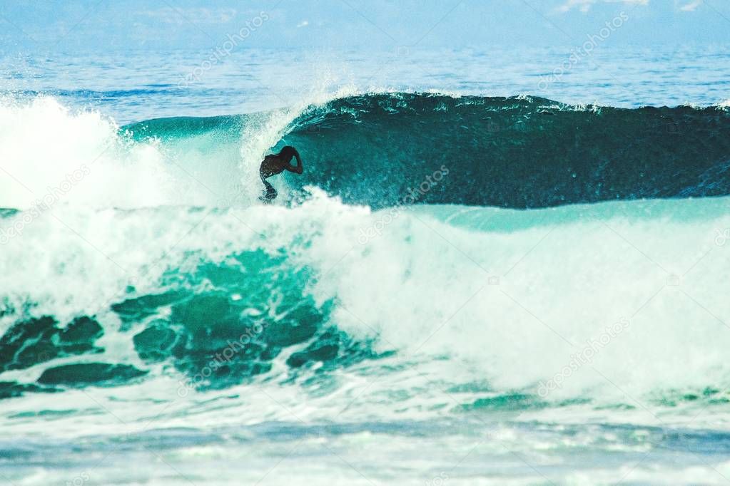 surfer catching breaking wave in Bali