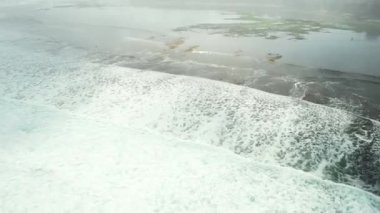 Yeşil deniz suyu dokusunun yüksek irtifasından havadan aşağıya doğru. Kamera suyun üzerinde uçuyor, su yüzeyini görüyor. Su yüzeyinin arka planı