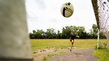 Yetişkin sporcu adam dışarıda futbol oynuyor.