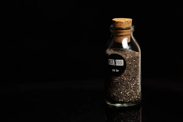 黑色背景玻璃瓶中有机奇亚种子的特写 — 图库照片