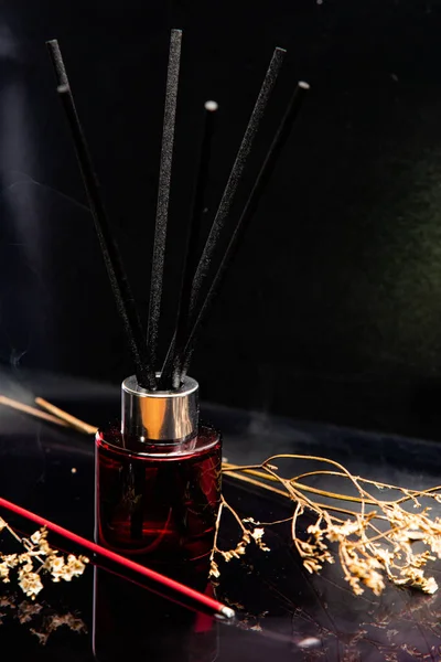 Tütsü çubuklarının ve siyah arkaplandaki kuru dalların yakın plan görüntüsü