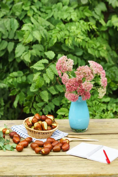 Wicker basket with Ziziphus real fruits, cobblestone, unabi, capiente, marmalade, capiinit, jojoba, Chinese date and vase with prominent stonecrop (lat. Hylotelephium spectabile)