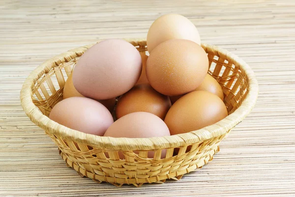 Real farm chicken eggs lie in a wicker basket on the table