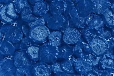 Kurutulmuş hurma dilimlerinin turuncu arkaplanı elektrik kurutucusunun beyaz ızgarasına yerleştirilmiş. Lezzetli ve sağlıklı ürünler. Klasik Maviyle Boyama