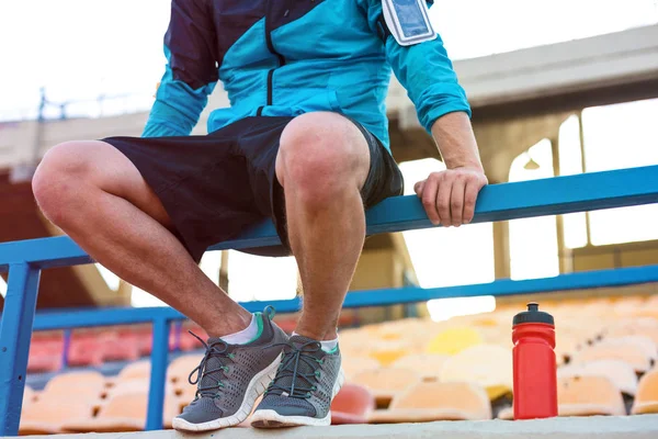 Sportler sitzt mit Wasserflasche am Geländer — Stockfoto