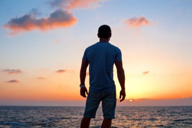 adam siluet batımında denize yakın