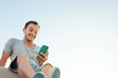 yakışıklı adam bankta oturan hareket eden smartphone ile