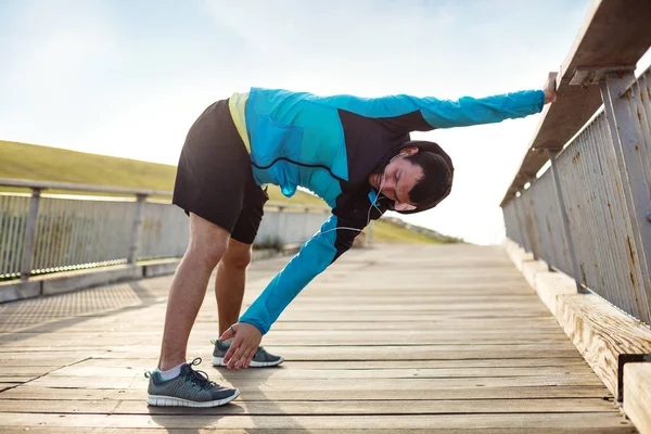 Sportsman gör uppvärmningen stretching övning i parken — Stockfoto