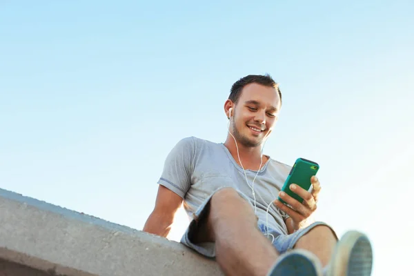Молодий і красивий чоловік з мобільним смартфоном сидить — стокове фото