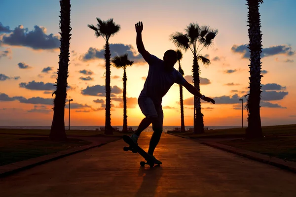 man riding on skateboard in sunset