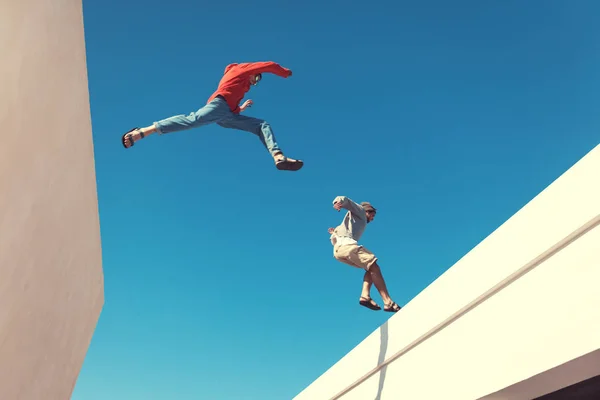 두 용감한 남자는 지붕 위로 점프 — 스톡 사진