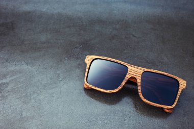 ahşap güneş gözlüğü ve parlak koyu arka plan