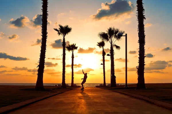 man riding on skateboard near the ocean