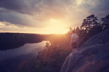 günbatımı Nehri yakınında bakarak sırt çantası ile seyahat adam