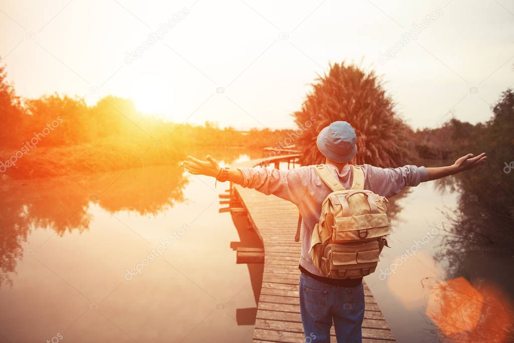happy traveler on the lake with outspread hands looking
