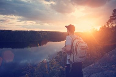 Casual adam sırt çantası ve nehir ve uzakta arıyorum yukarıda Uçurumdaki kap
