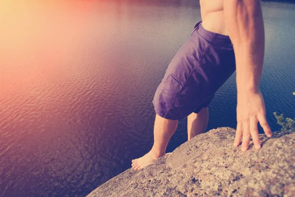 Man preparing to jump into river from high cliff — Stock Photo, Image
