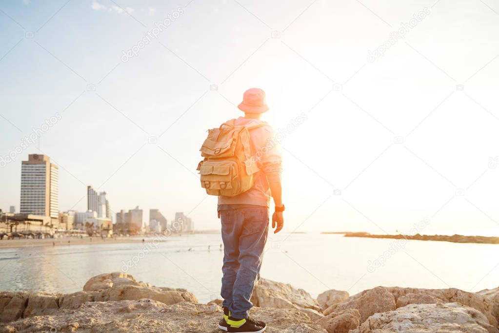traveler standing on the rocks near the sea
