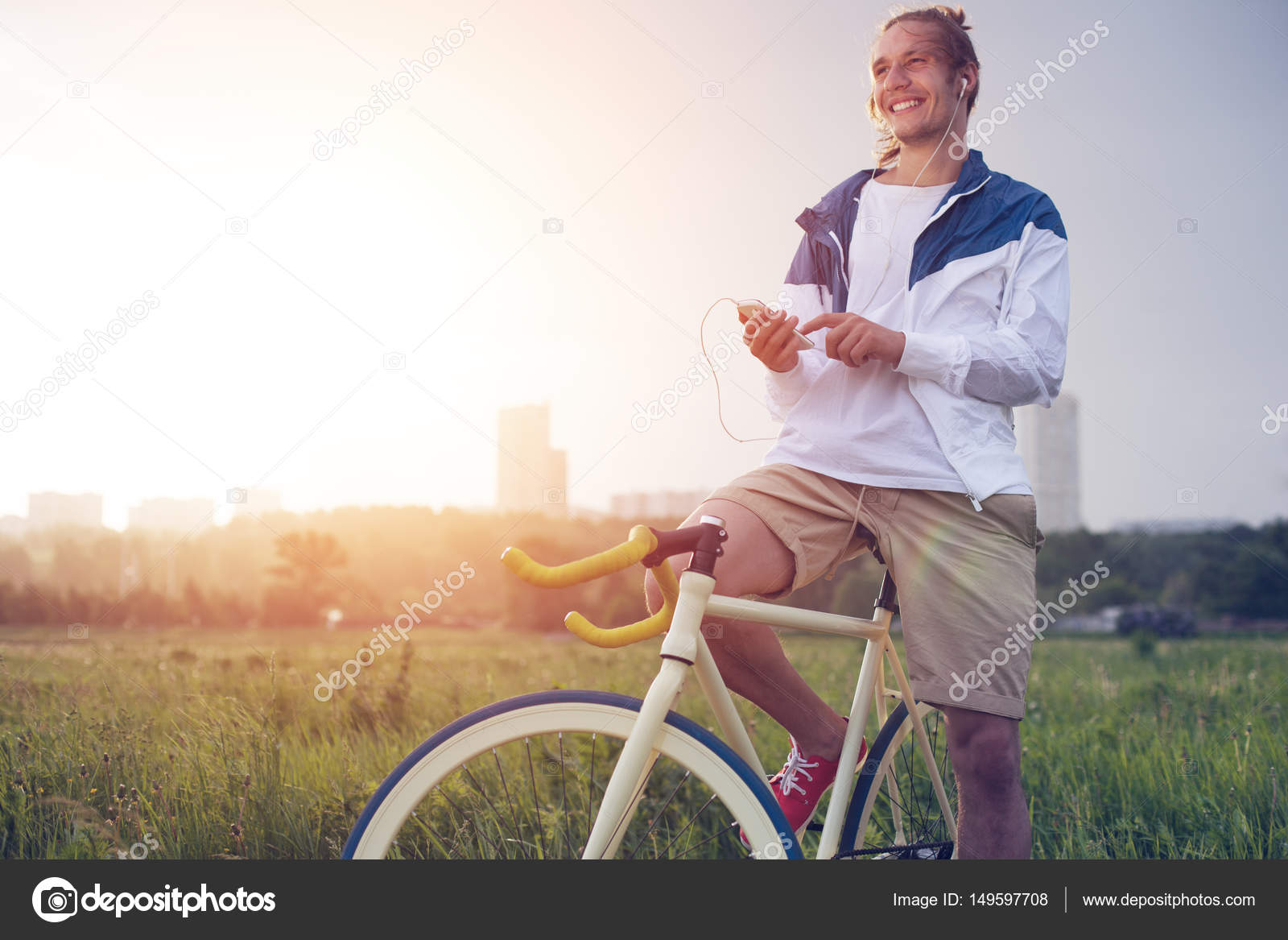 Long hair man with bicycle in green field Stock Photo by ©mooshny 149597708