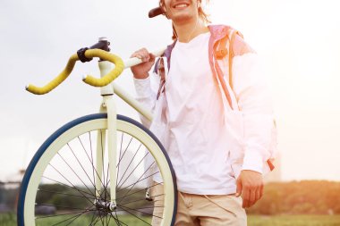 genç adam onun omuz üzerinde bisiklet ile boş t-shirt ayakta