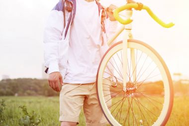 genç adam onun omuz üzerinde bisiklet ile boş t-shirt ayakta