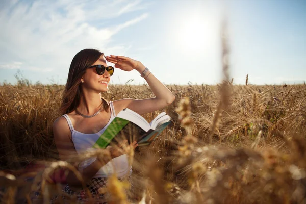 sıklıkta dinlenme bir kitapla güneş gözlüklü kız