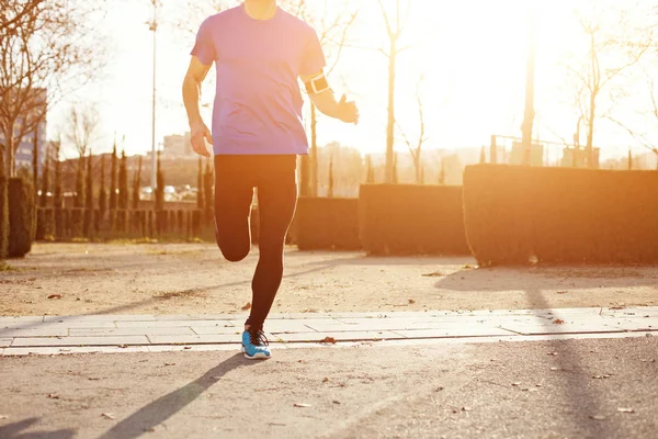 Біг спортсмен в парку на заході сонця — стокове фото